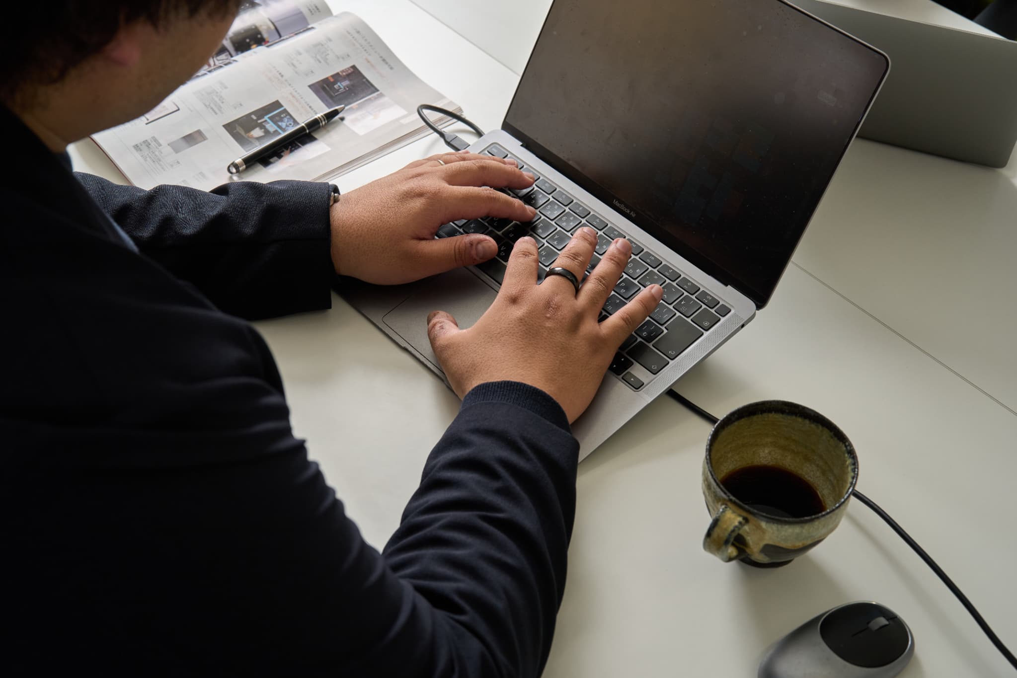 ノートパソコンを操作する男性の手