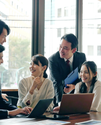 笑顔で会議する5人の会社員