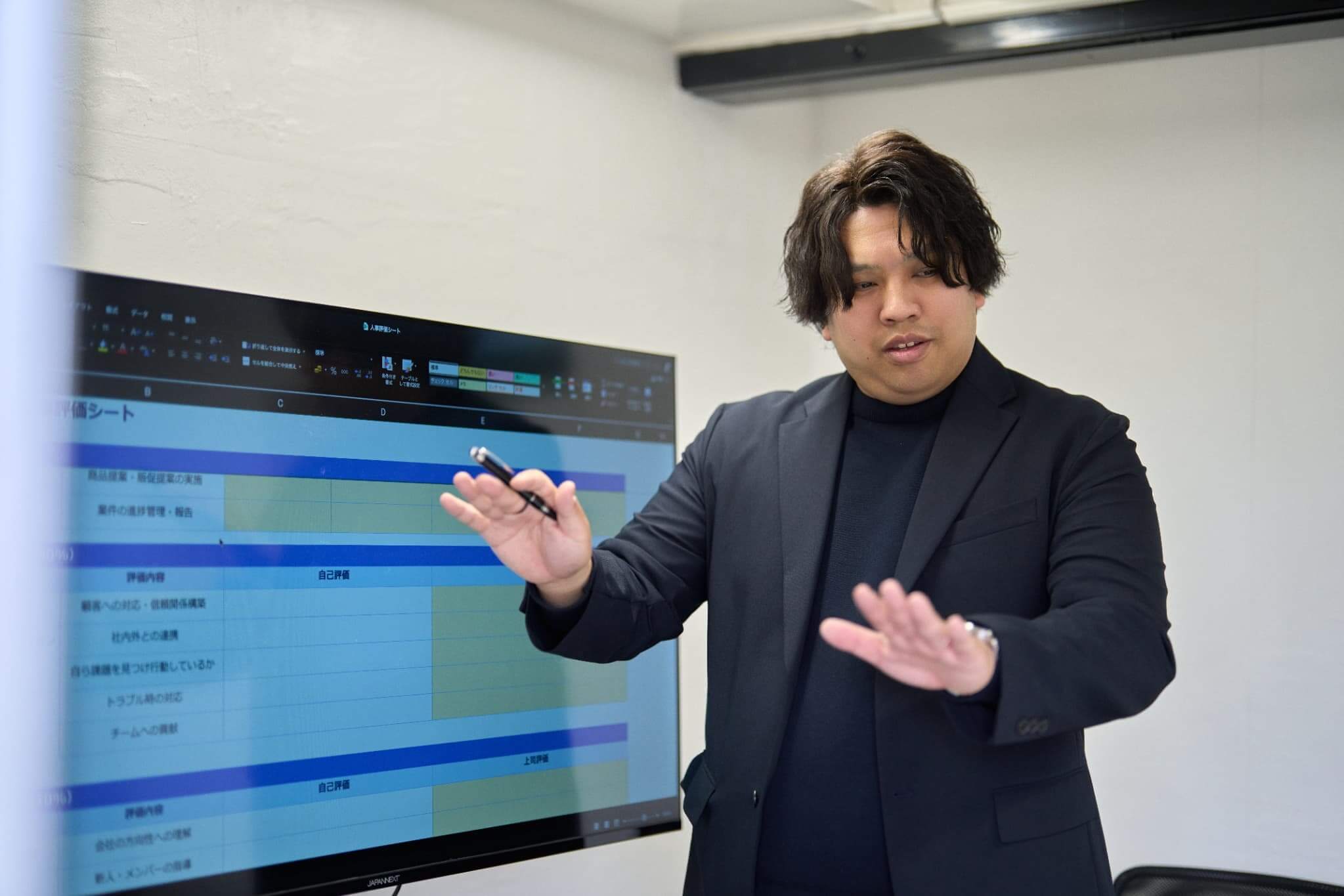 プレゼンでテレビ画面を操作する男性